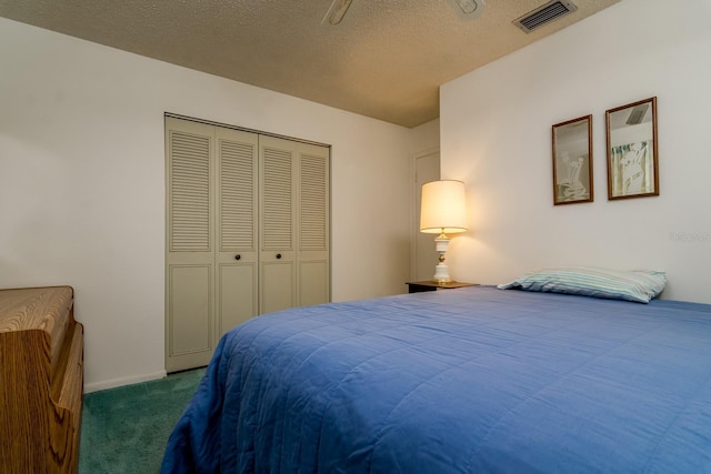 bedroom featuring a closet, visible vents, dark carpet, a textured ceiling, and baseboards