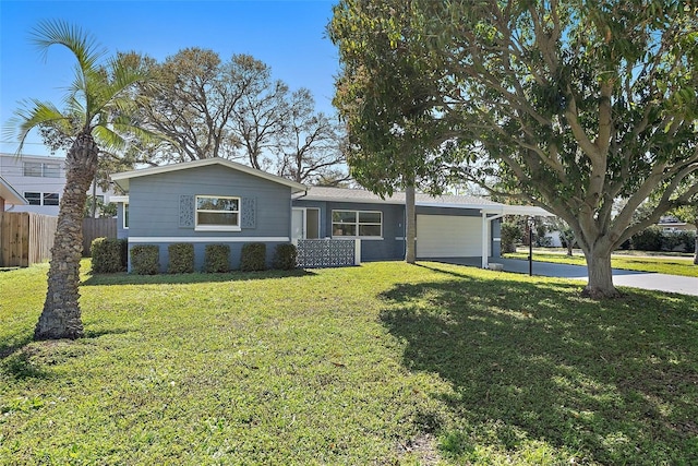 single story home featuring driveway, a front lawn, fence, and an attached carport