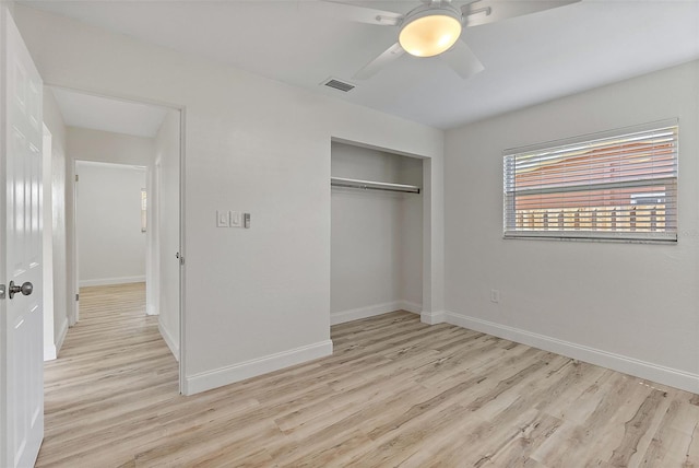 unfurnished bedroom with baseboards, visible vents, ceiling fan, wood finished floors, and a closet