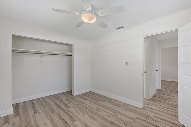 unfurnished bedroom with ceiling fan, wood finished floors, visible vents, baseboards, and a closet