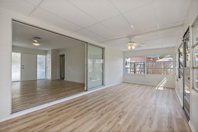 unfurnished sunroom featuring a paneled ceiling, visible vents, and a ceiling fan