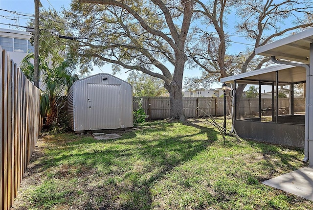 view of yard featuring a sunroom, a shed, a fenced backyard, and an outbuilding