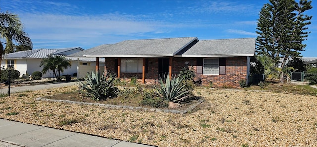 ranch-style house featuring cooling unit and brick siding