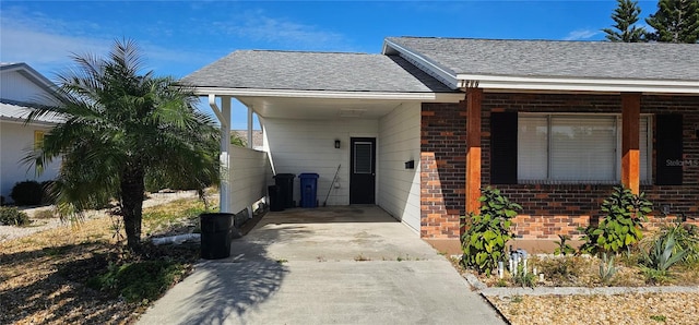 view of front facade featuring a shingled roof, concrete driveway, and brick siding