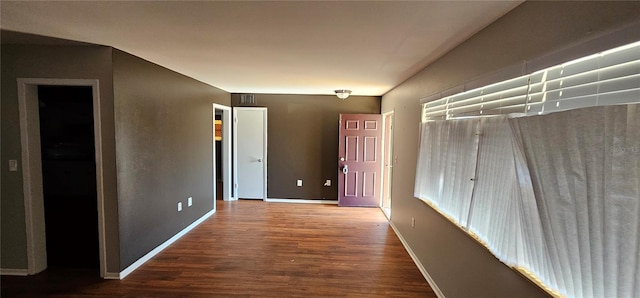 corridor with wood finished floors and baseboards