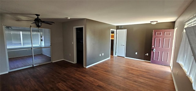 unfurnished bedroom featuring a ceiling fan, visible vents, baseboards, and wood finished floors