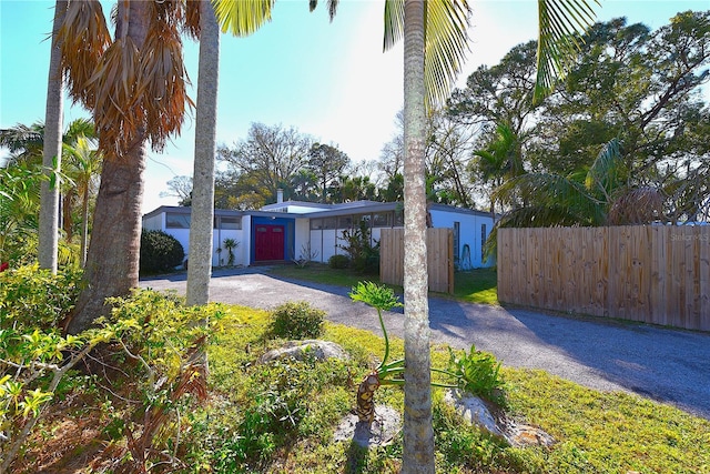 view of front facade featuring aphalt driveway and fence