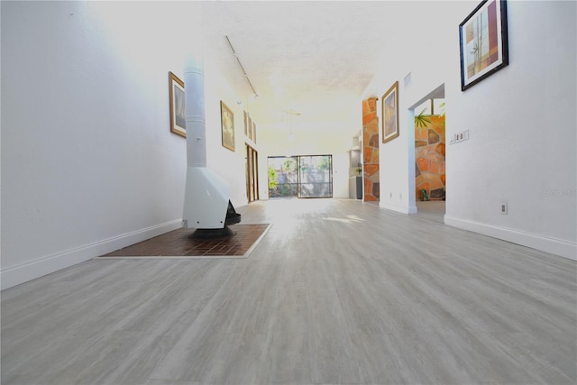 hall with wood finished floors, visible vents, and baseboards