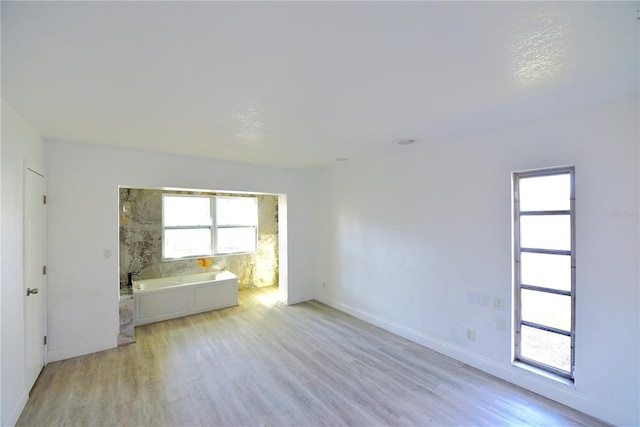 empty room with baseboards and light wood-style floors