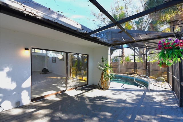 view of patio / terrace featuring glass enclosure, a fenced in pool, and a wooden deck