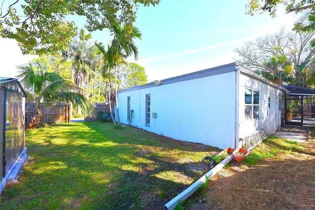 view of side of property with fence and a yard