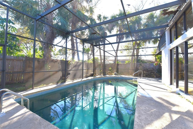 view of pool featuring a fenced in pool, glass enclosure, a patio, and a fenced backyard