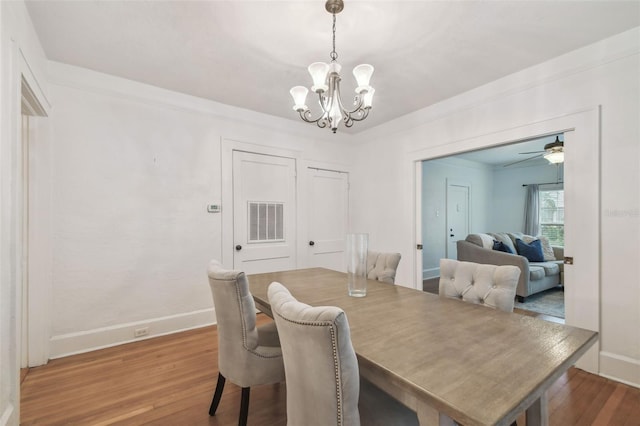 dining room with baseboards, crown molding, visible vents, and wood finished floors