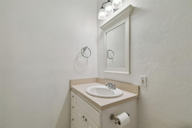 bathroom with a textured wall and vanity