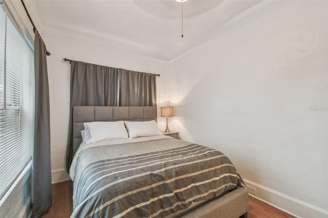 bedroom with ceiling fan, dark wood-type flooring, and baseboards