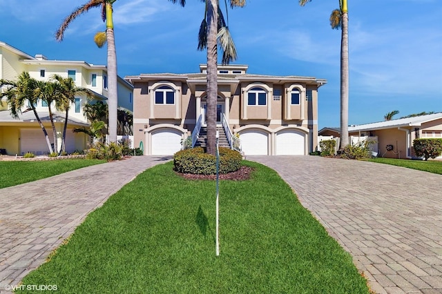 view of front of house featuring a garage, stucco siding, stairs, decorative driveway, and a front yard