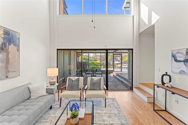 living room featuring a high ceiling, wood finished floors, and baseboards