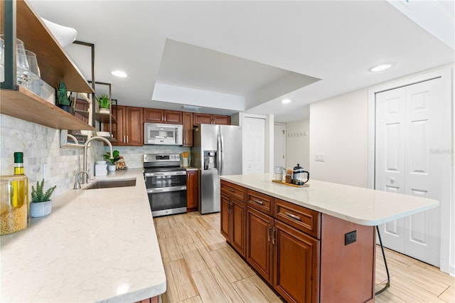 kitchen featuring stainless steel appliances, a breakfast bar, a sink, decorative backsplash, and open shelves