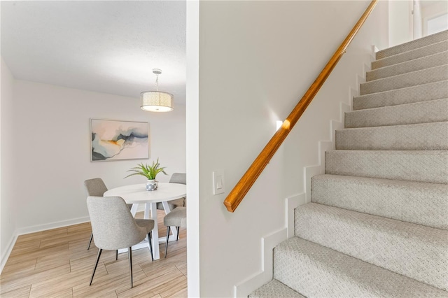 stairway featuring baseboards and wood finished floors