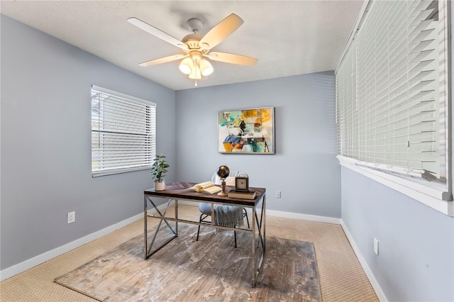 office area featuring carpet floors, baseboards, and a ceiling fan