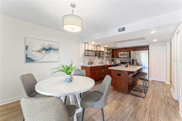 dining room with light wood-style floors, recessed lighting, visible vents, and baseboards