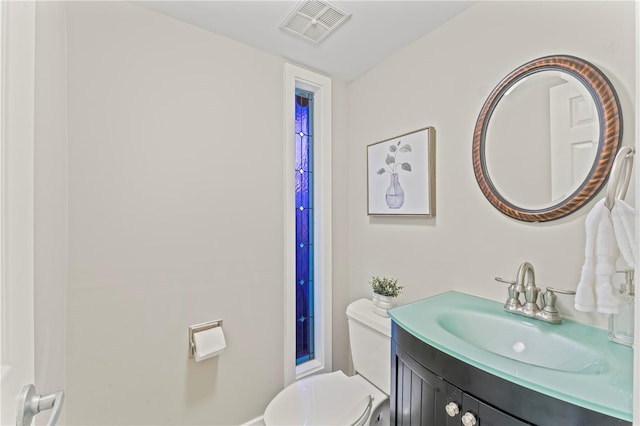 bathroom featuring toilet, visible vents, and vanity