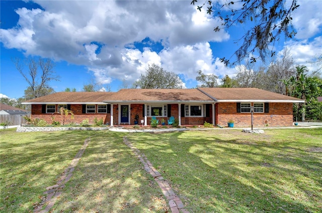 ranch-style house with a porch, a front yard, and brick siding