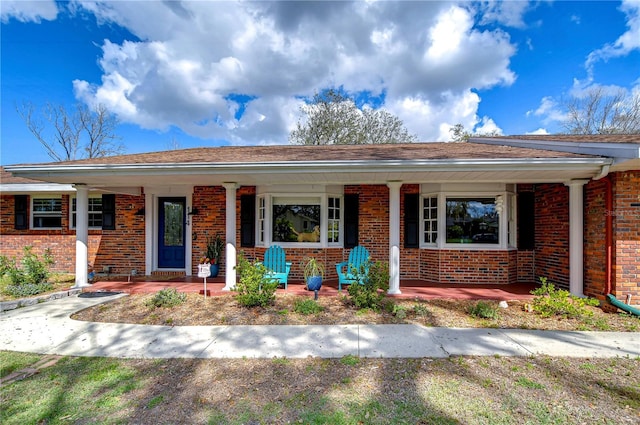 ranch-style house with a porch and brick siding