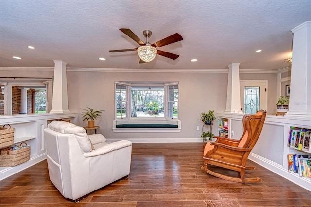 sitting room with a textured ceiling, wood finished floors, and decorative columns