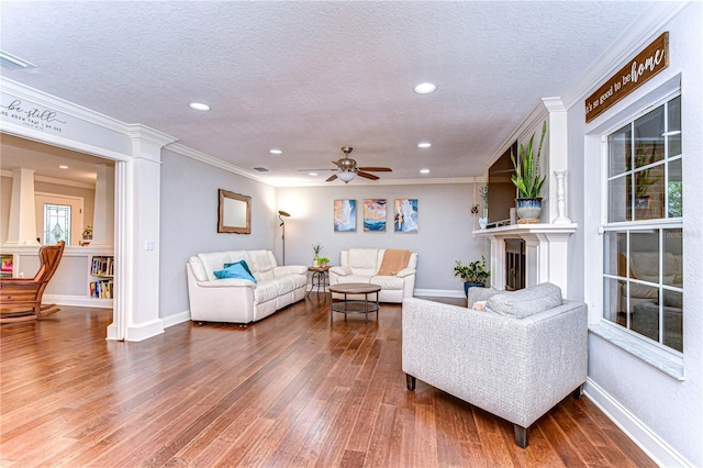 living area featuring crown molding, a textured ceiling, and wood finished floors