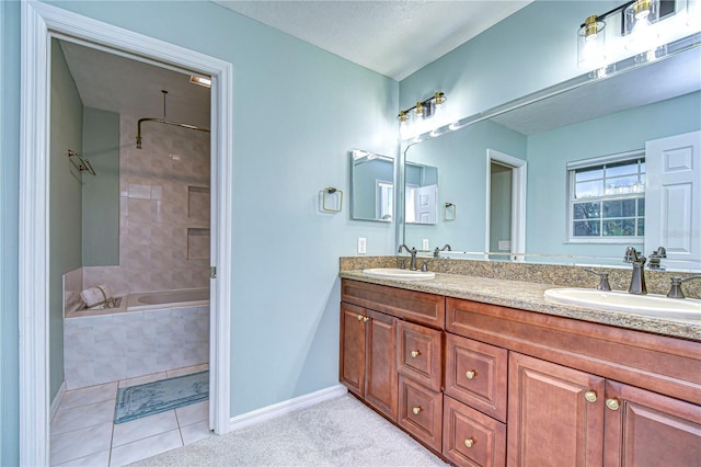 bathroom featuring a relaxing tiled tub, a sink, baseboards, and double vanity