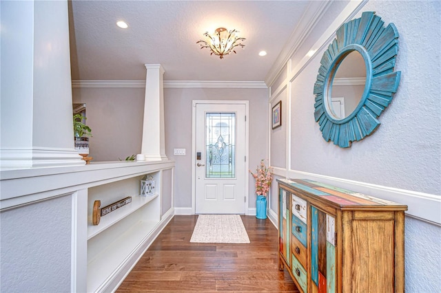 foyer entrance with recessed lighting, wood finished floors, decorative columns, and crown molding