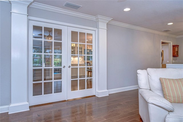 unfurnished room with baseboards, visible vents, wood finished floors, and ornamental molding