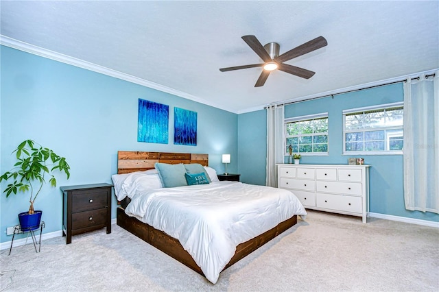 carpeted bedroom with a ceiling fan, crown molding, and baseboards