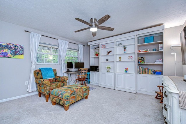 sitting room featuring light carpet, ceiling fan, a textured ceiling, and baseboards