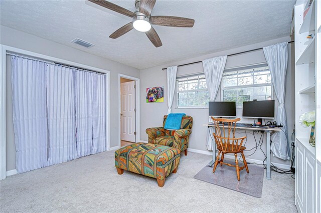 office space featuring carpet floors, visible vents, a textured ceiling, and baseboards