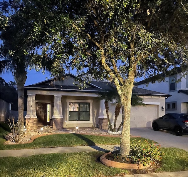 view of front of home with concrete driveway, stone siding, an attached garage, and stucco siding