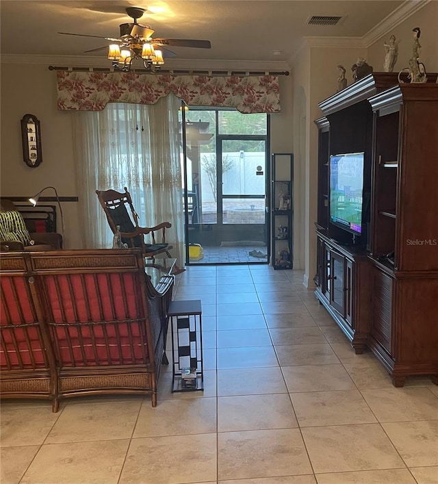 interior space featuring light tile patterned floors, a ceiling fan, visible vents, and crown molding