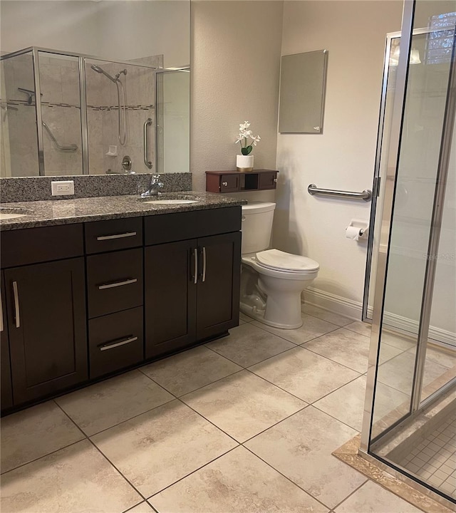 bathroom with tile patterned flooring, a shower stall, toilet, and double vanity