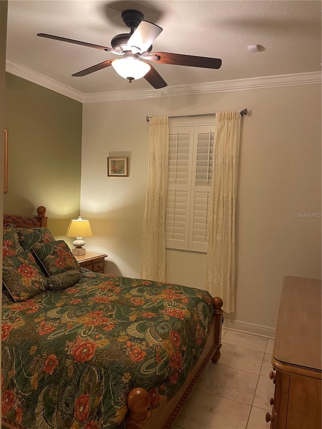 bedroom featuring ornamental molding, a ceiling fan, light tile patterned flooring, a textured ceiling, and baseboards