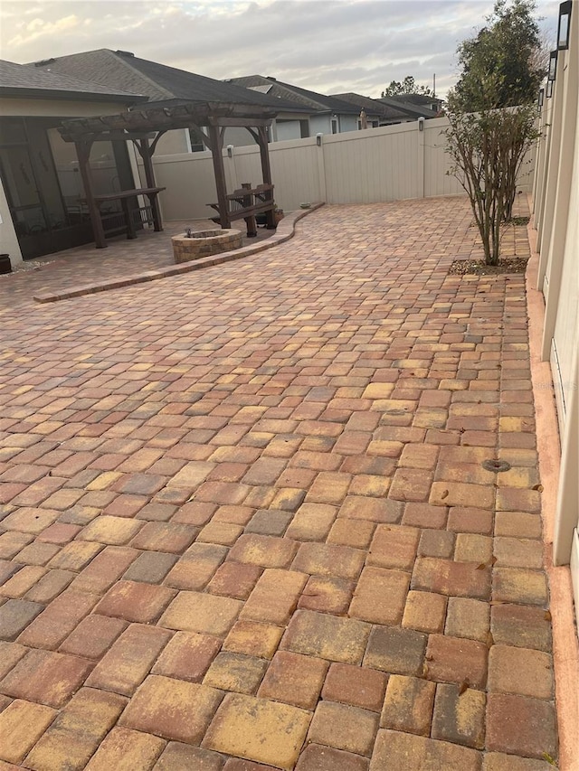 view of patio featuring an outdoor fire pit and fence