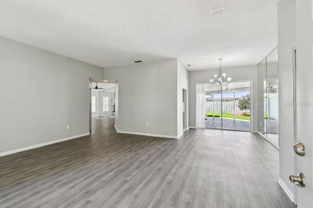915 Brittany Park Blvd, Tarpon Springs, FL 34689 - unfurnished living room with a textured ceiling, plenty of natural light, wood finished floors, a chandelier, and baseboards