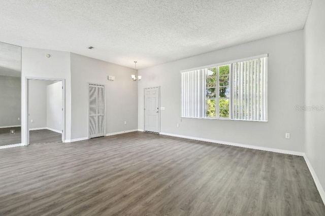 915 Brittany Park Blvd, Tarpon Springs, FL 34689 - unfurnished living room with a textured ceiling, dark wood-type flooring, baseboards, and a chandelier