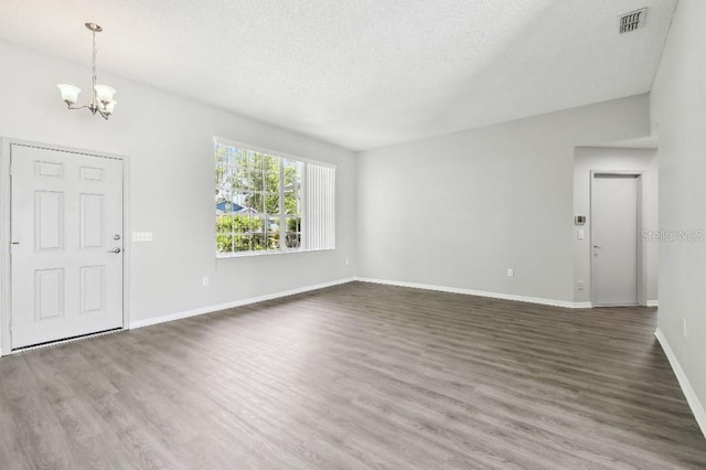 915 Brittany Park Blvd, Tarpon Springs, FL 34689 - foyer entrance with a chandelier, a textured ceiling, wood finished floors, and baseboards