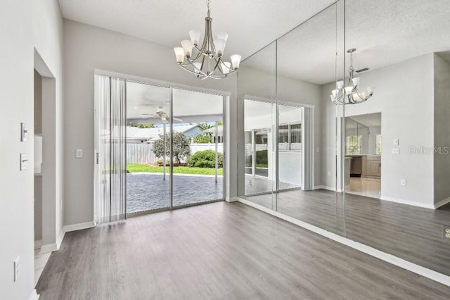 915 Brittany Park Blvd, Tarpon Springs, FL 34689 - unfurnished dining area featuring a chandelier, wood finished floors, baseboards, a textured ceiling, and a ceiling fan