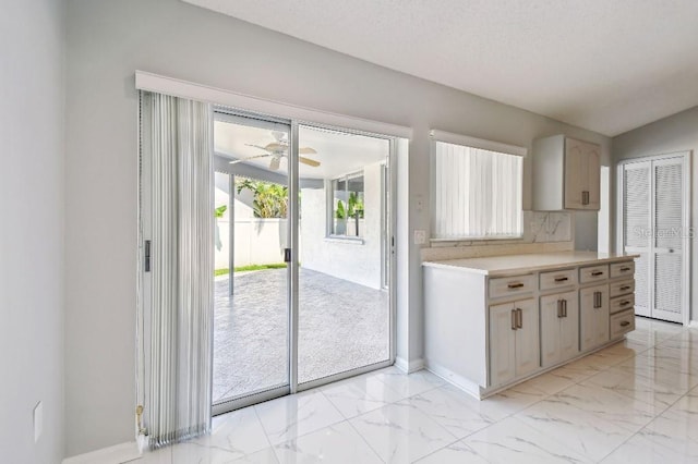 915 Brittany Park Blvd, Tarpon Springs, FL 34689 - kitchen featuring light marble finish floors, light countertops, a ceiling fan, and backsplash