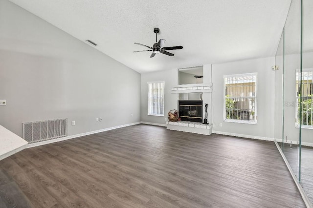 915 Brittany Park Blvd, Tarpon Springs, FL 34689 - unfurnished living room featuring plenty of natural light, a ceiling fan, a brick fireplace, lofted ceiling, and dark wood-style floors