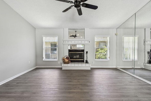 915 Brittany Park Blvd, Tarpon Springs, FL 34689 - unfurnished living room with ceiling fan, a textured ceiling, dark wood-style floors, baseboards, and a fireplace