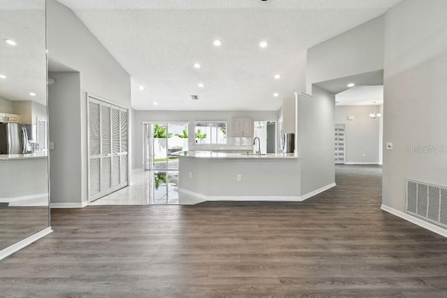 915 Brittany Park Blvd, Tarpon Springs, FL 34689 - unfurnished living room with vaulted ceiling, a sink, recessed lighting, baseboards, and wood finished floors