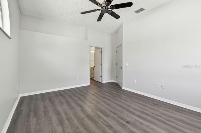 915 Brittany Park Blvd, Tarpon Springs, FL 34689 - spare room featuring ceiling fan, dark wood-type flooring, a textured ceiling, baseboards, and lofted ceiling